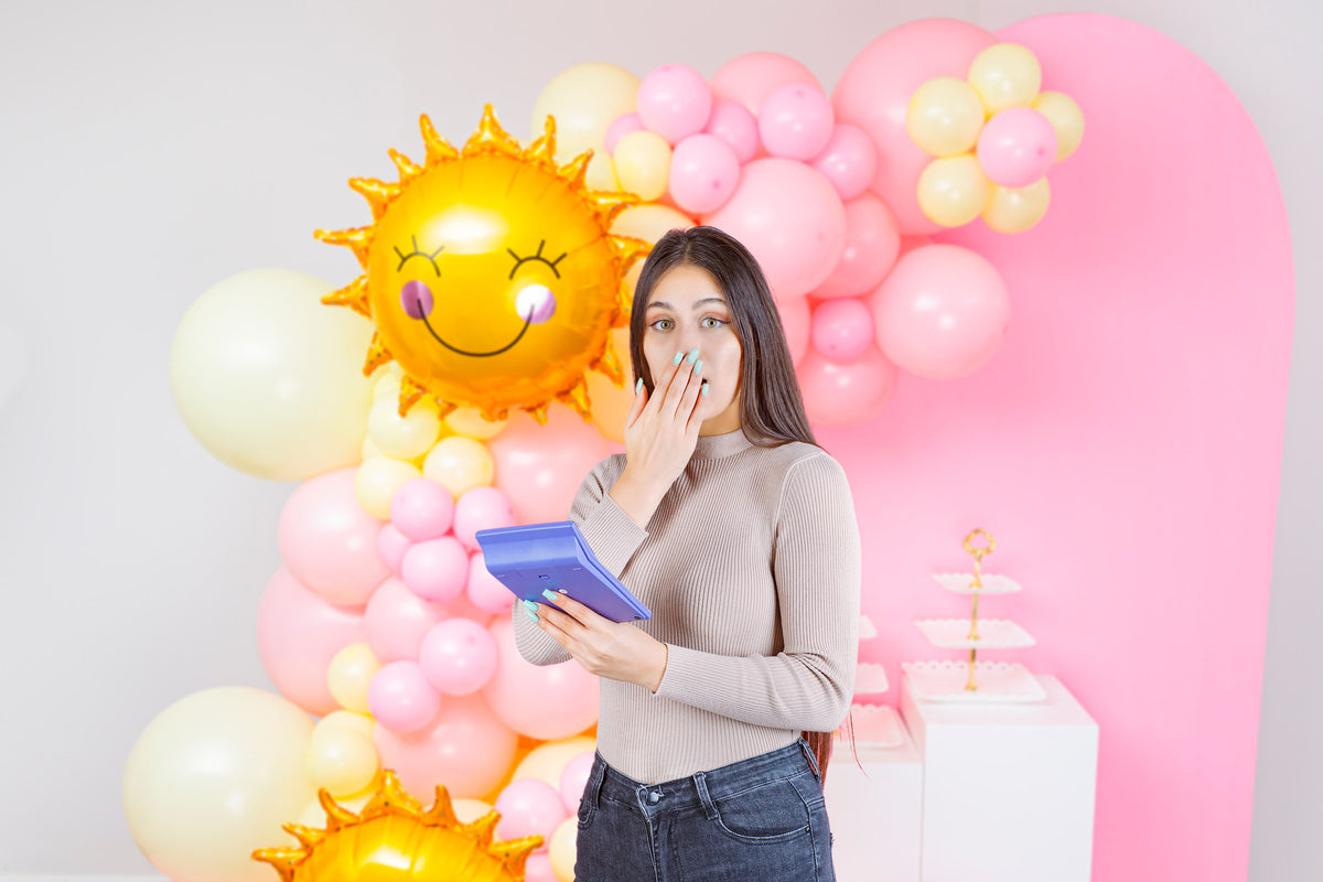 lady with calculator in front of balloon garland