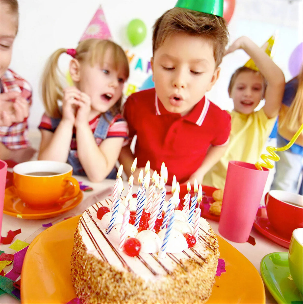 Children celebrating a birthday with cake and party hats